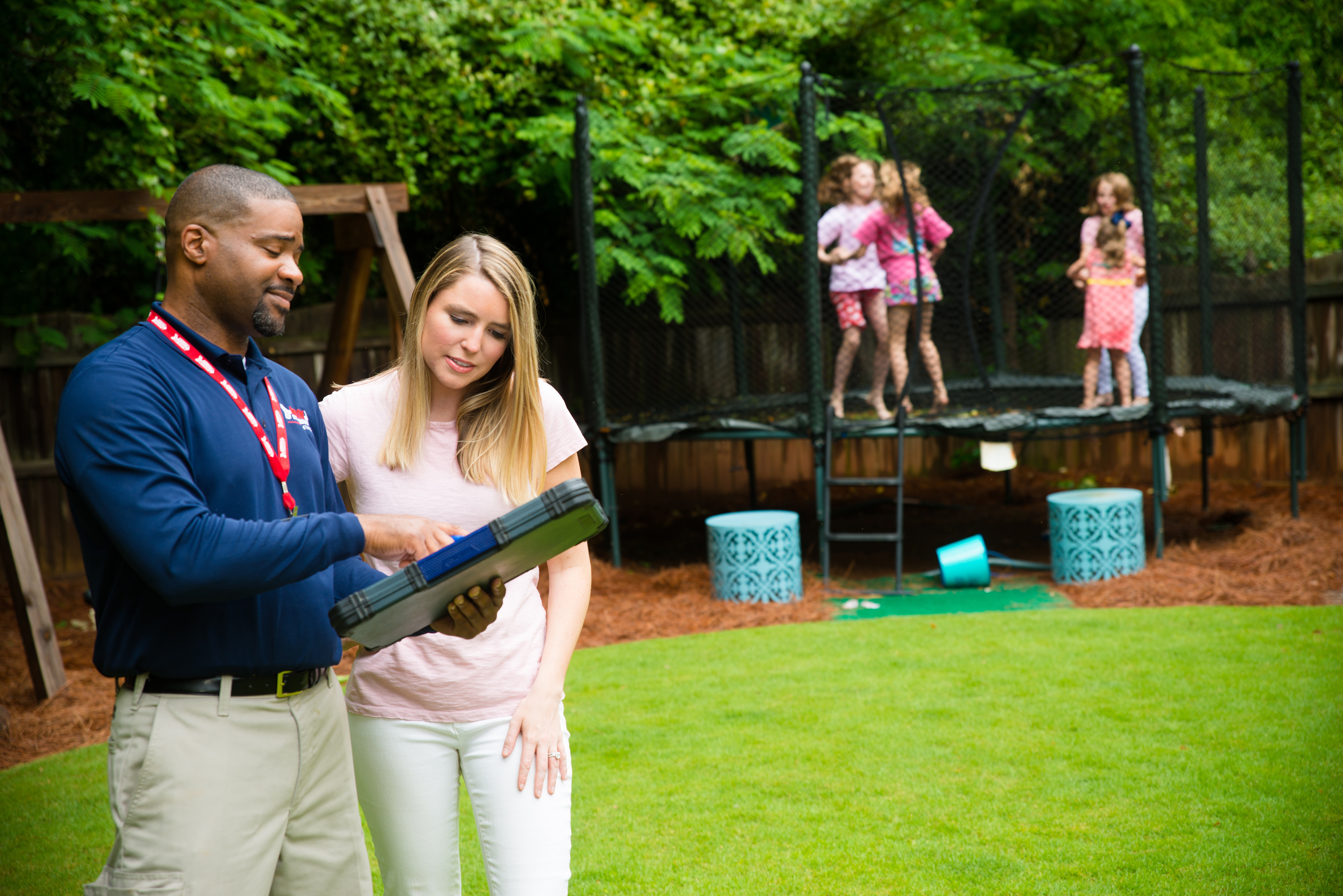 An Arrow employee showing a homeowner information on a clipboard.